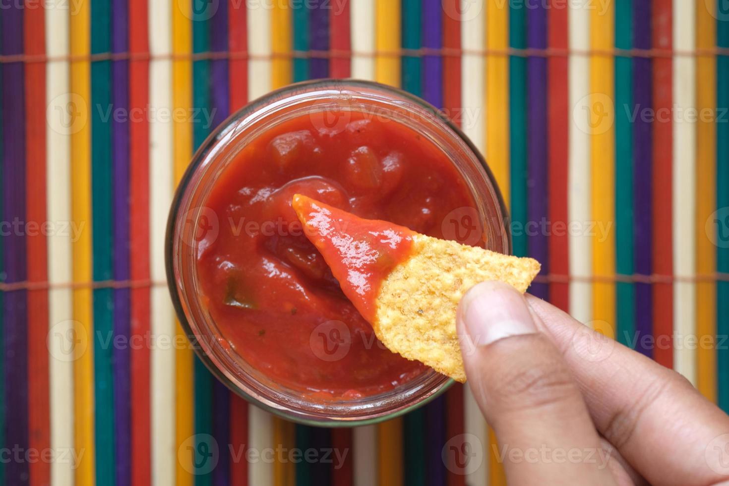 nachos doppar i en chili såser foto