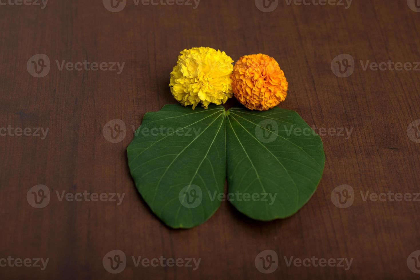 indisk festival dussehra, visar gyllene blad bauhinia racemosa och ringblommablommor på en brun bakgrund. foto