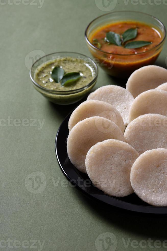 idli med sambar och kokosnötchutney, indisk maträtt sydindisk favoritmat rava idli eller semolina idly eller rava idly, serveras med sambar och grön chutney. foto