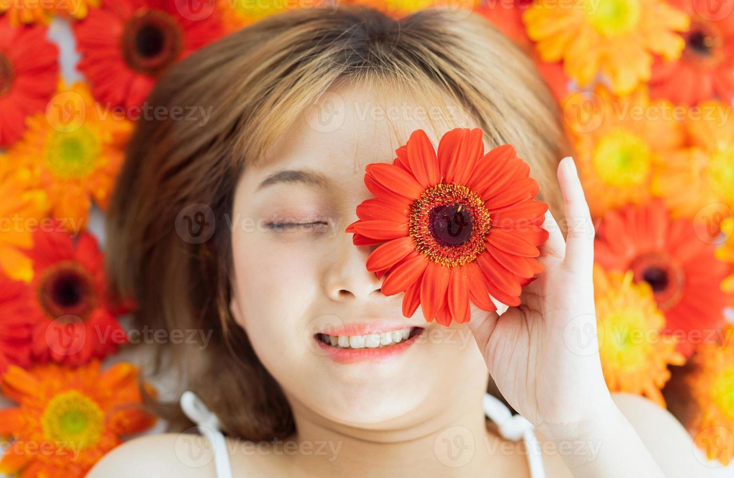 ung flicka som ligger på en blomma med ett lyckligt uttryck foto