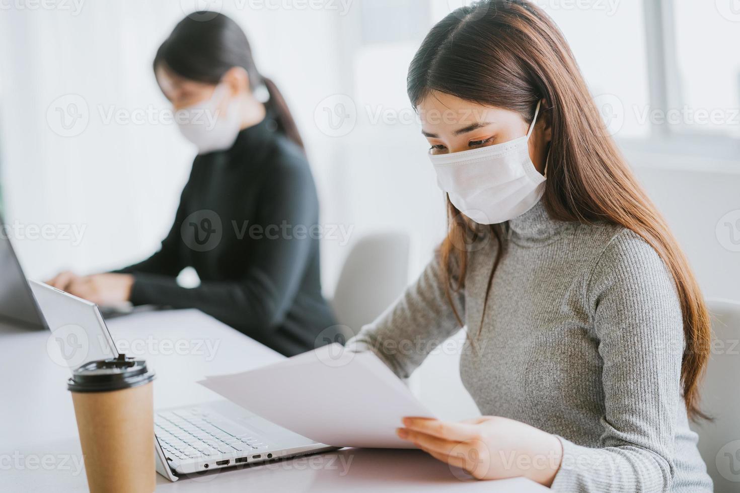 två kvinnor måste bära masker under arbetstiden för att vara säkra under epidemier foto