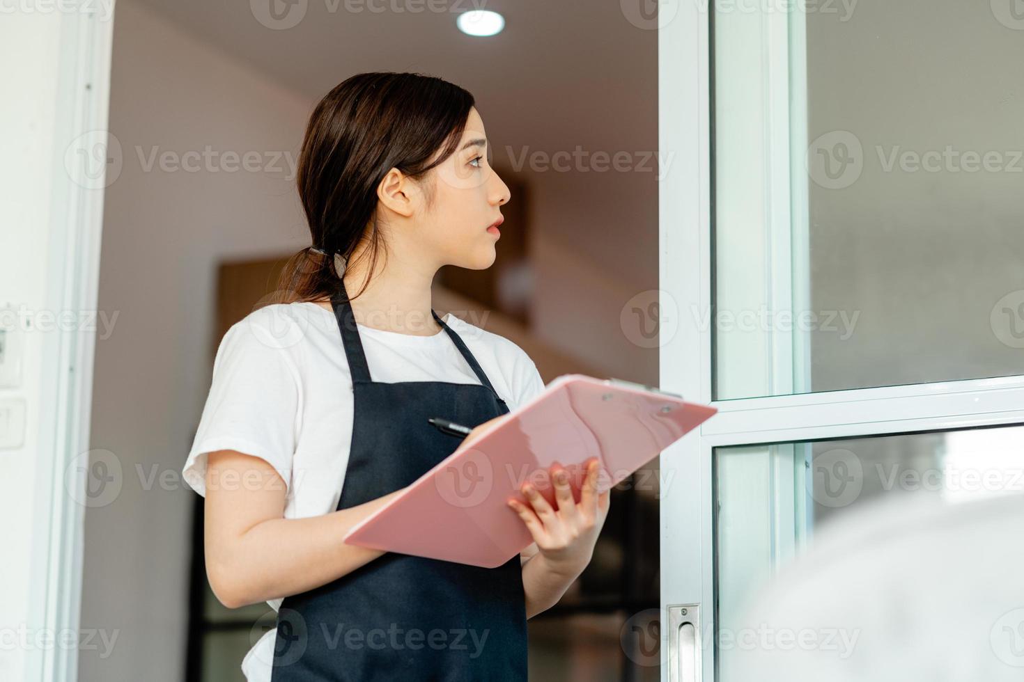 den asiatiska servitrisen kontrollerar hotellrummet när gästerna checkar ut foto