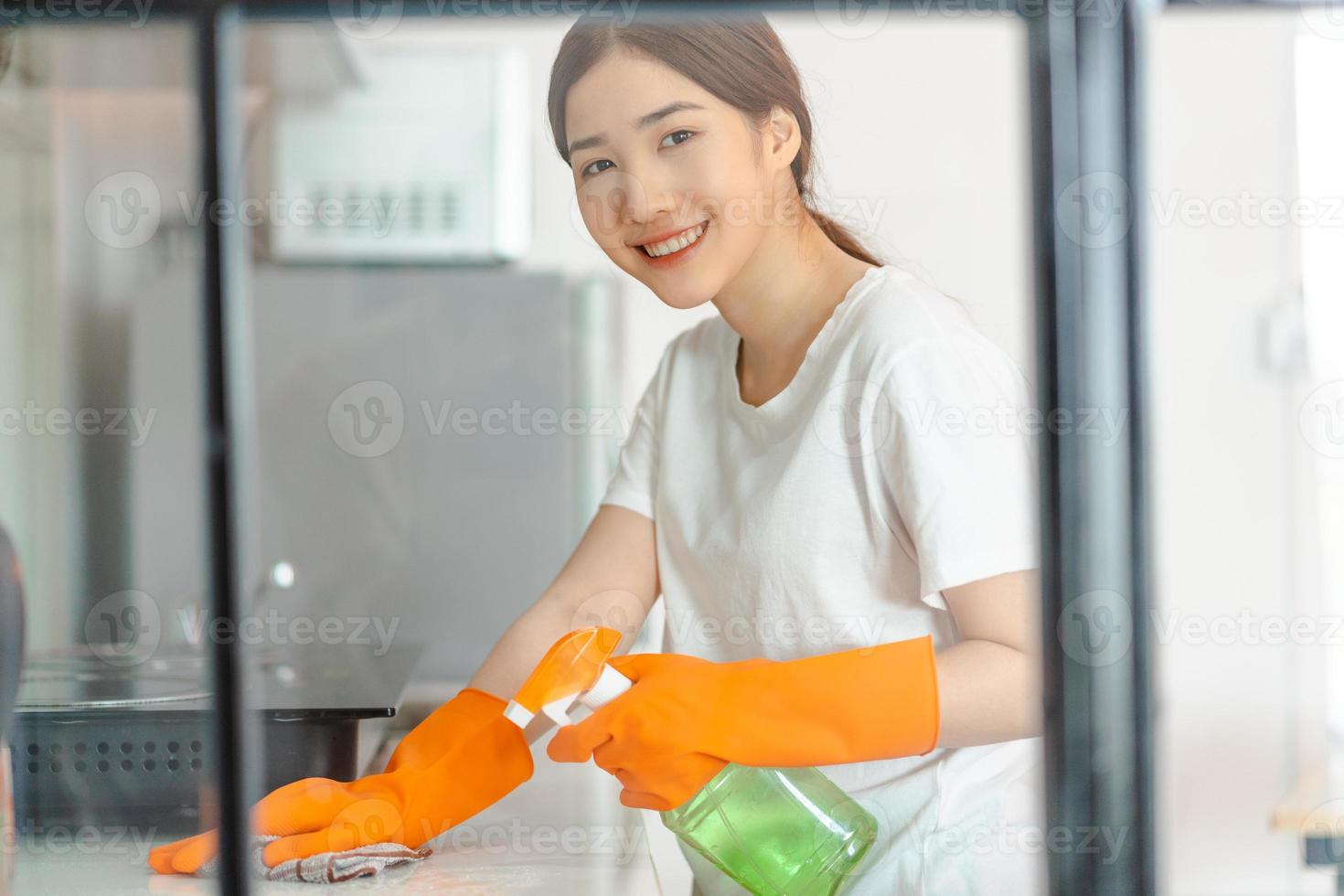 vacker asiatisk kvinna som städar köket foto