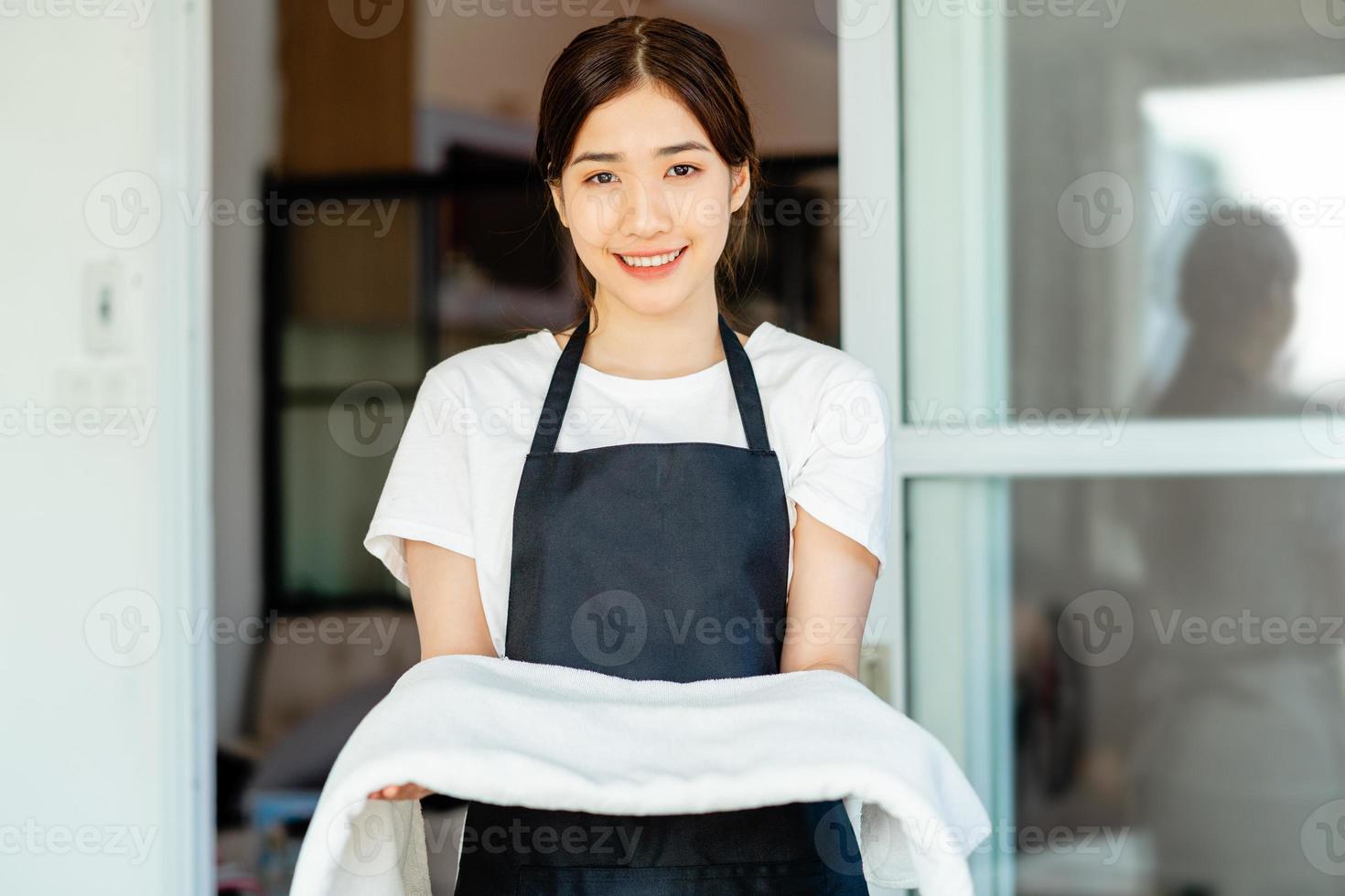 en asiatisk servitris förbereder handdukar för gästerna foto