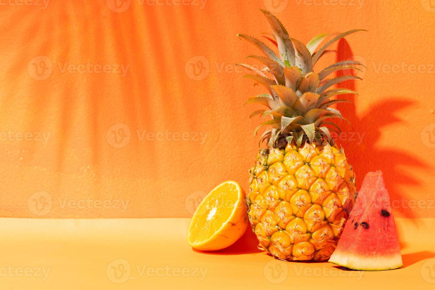 sommar koncept med apelsin, ananas och vattenmelon och orange bakgrund foto