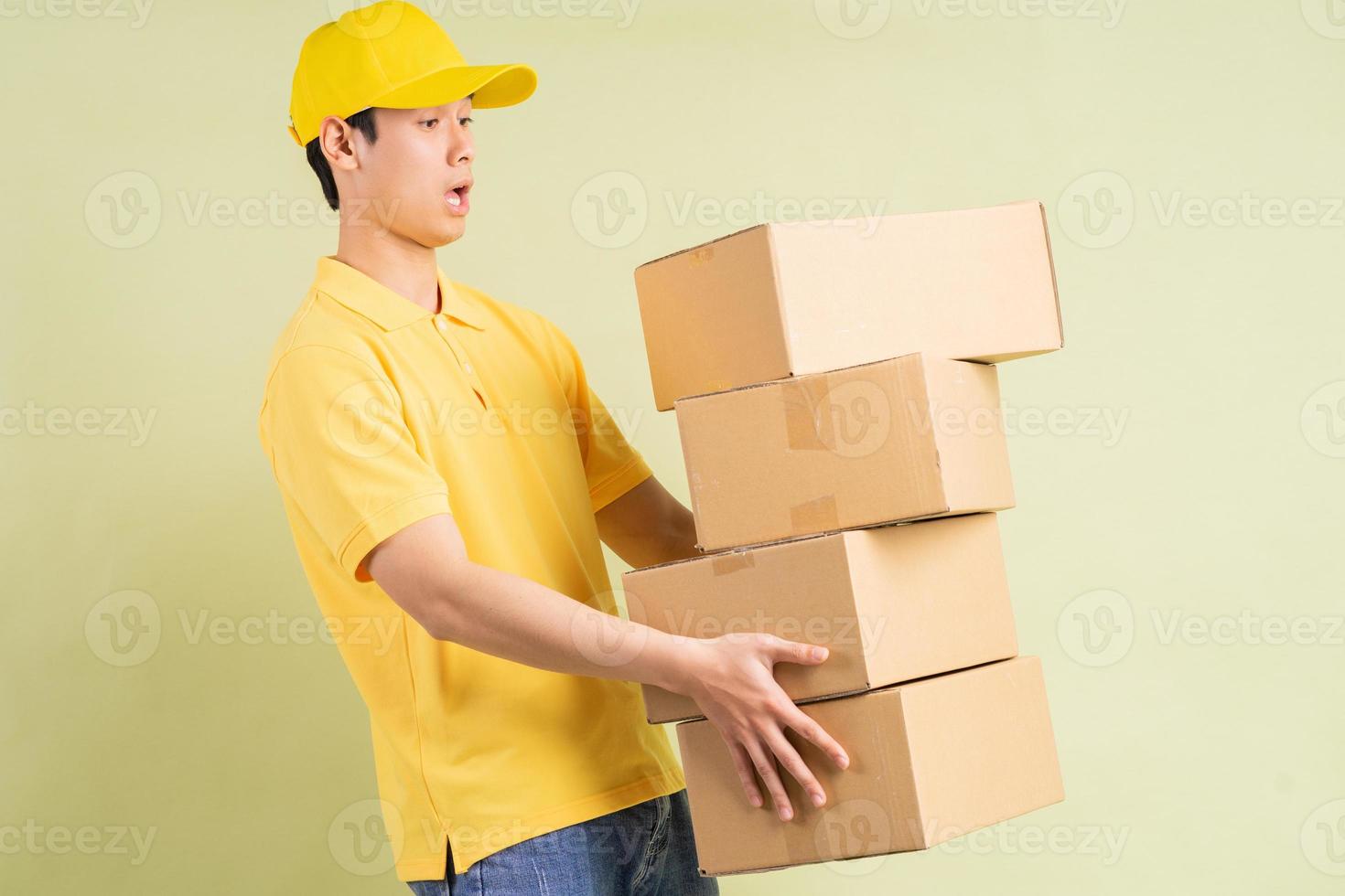 asiatisk leveransman håller kartongen med sig och springer för att leverera varorna foto