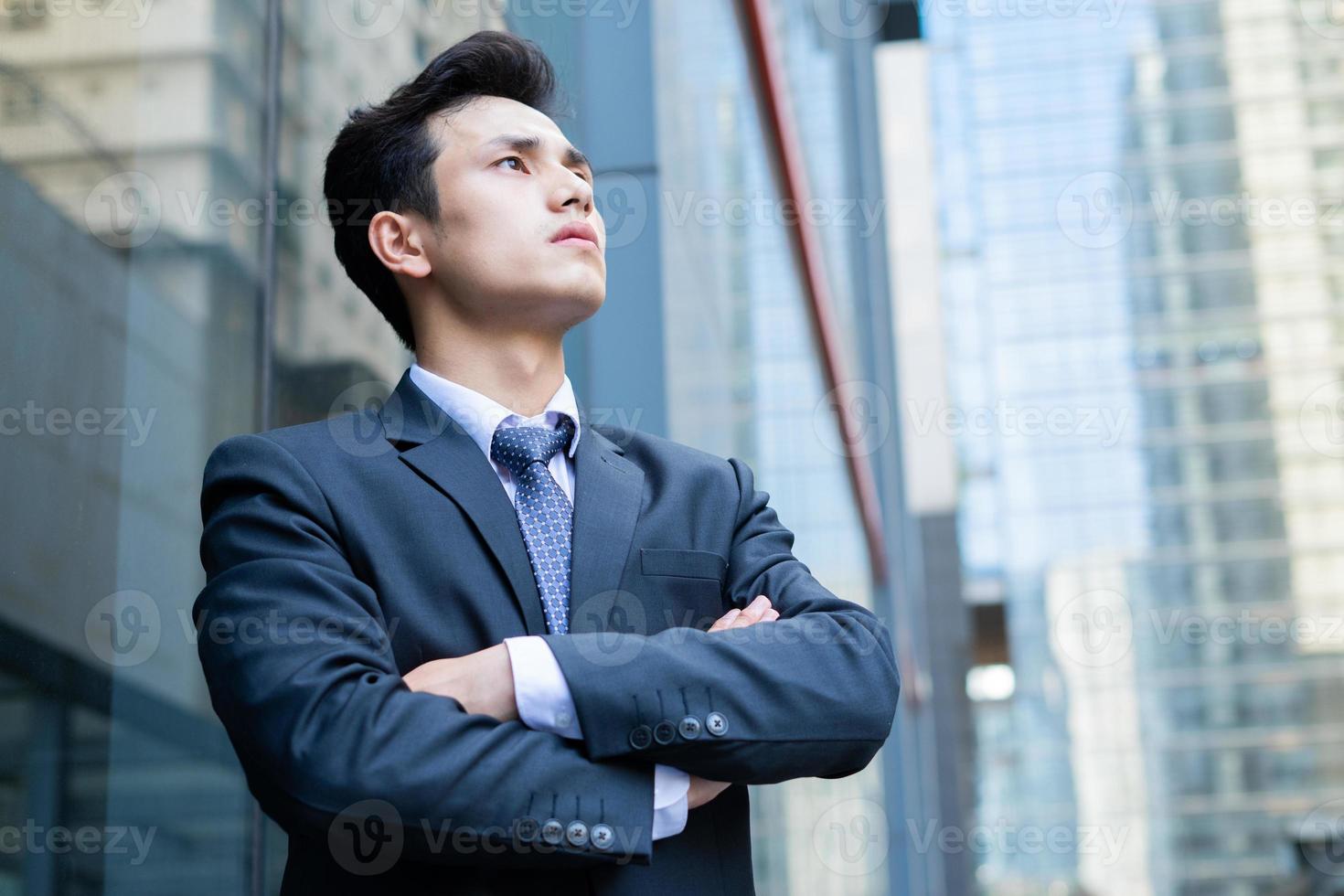 porträtt av ung asiatisk affärsman utanför kontoret foto