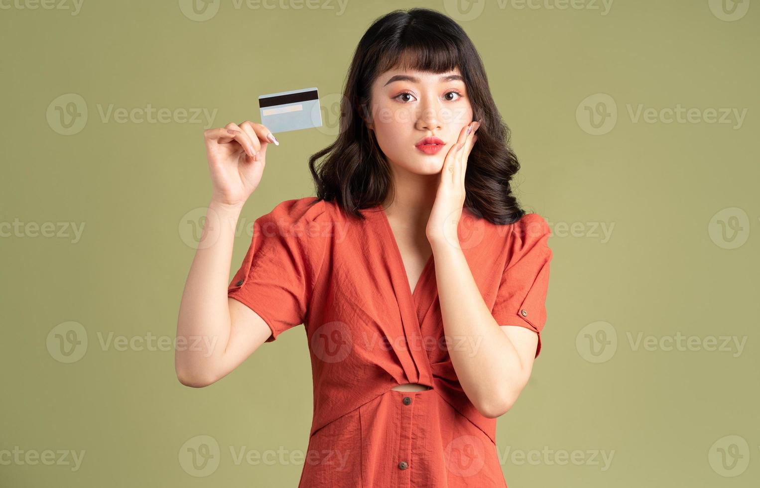 asiatisk kvinna håller bankkort foto