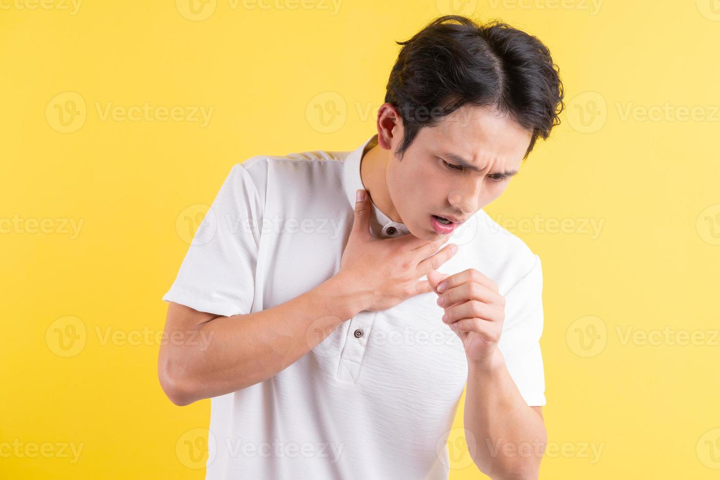 ett porträtt av en ung man som håller halsen i smärta foto