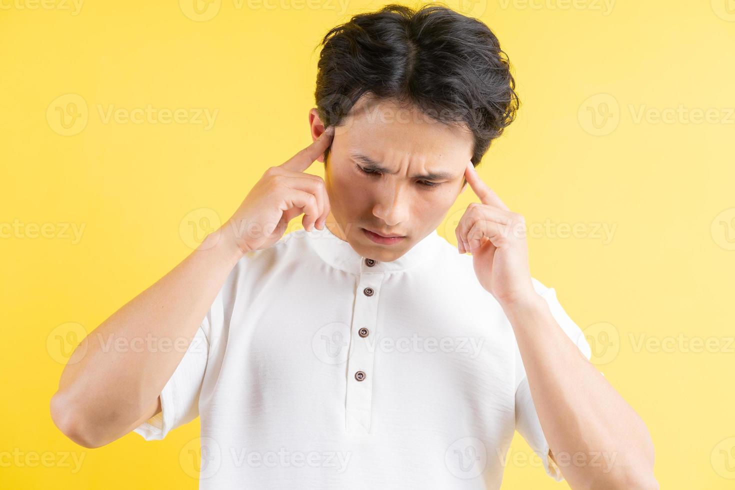 porträtt av ung man som har huvudvärk på en gul bakgrund foto