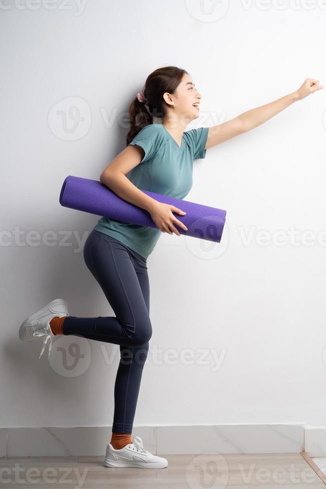 ung asiatisk kvinna som gör övning på vit bakgrund foto