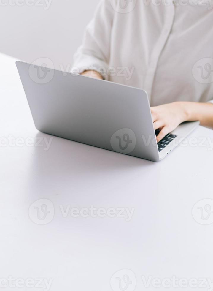beskuren bild av asiatisk affärskvinna som använder bärbara datorn foto