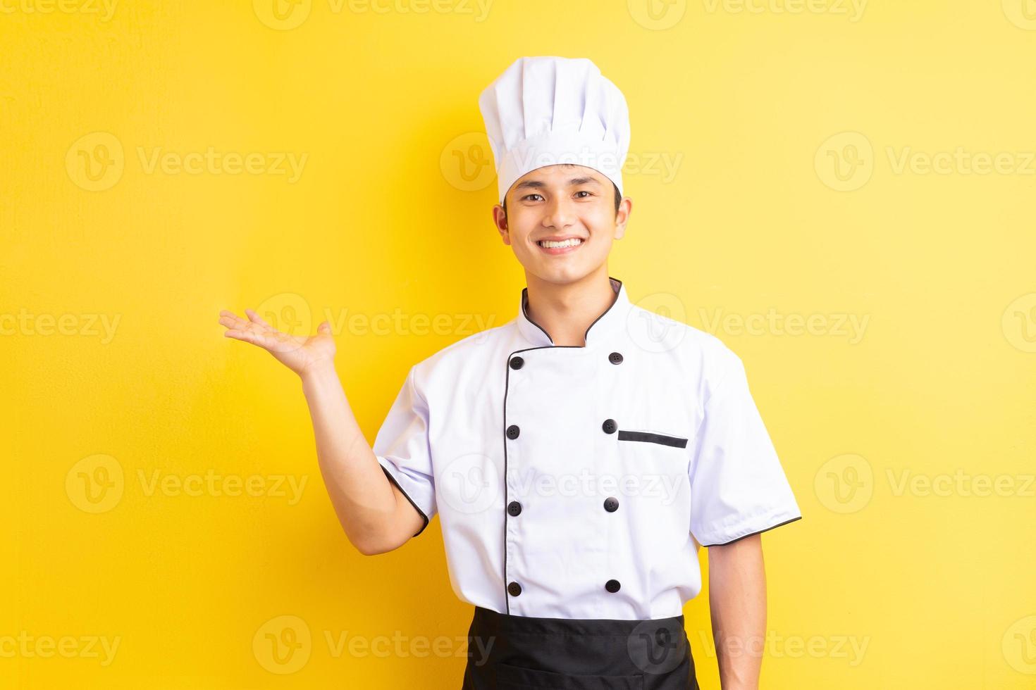 bild av asiatisk manlig kock på gul bakgrund foto