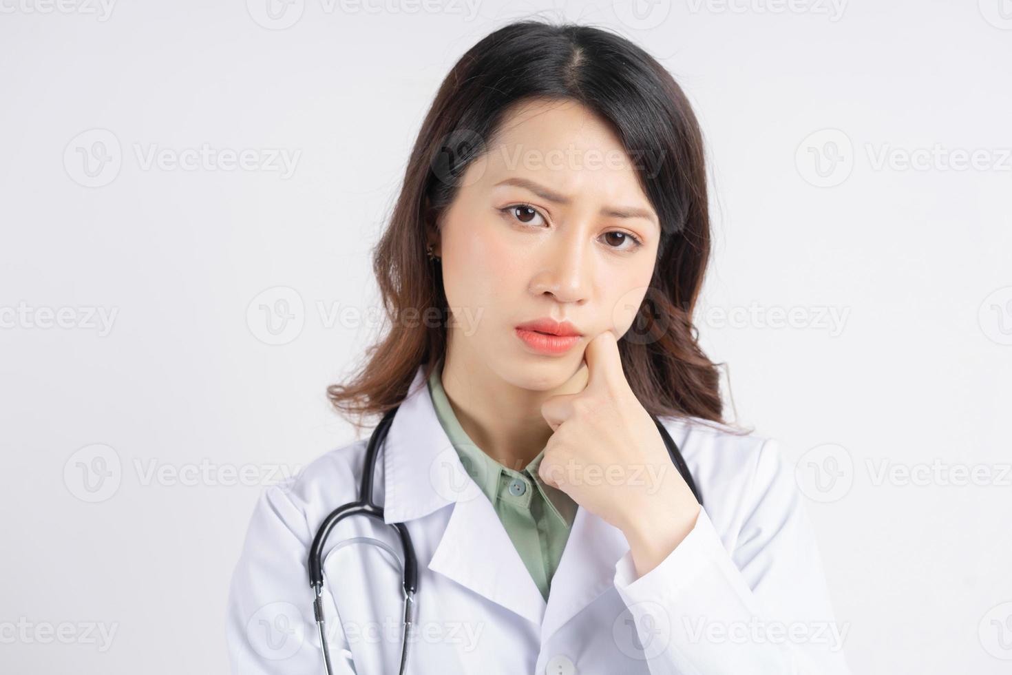 porträtt av asiatisk kvinnlig läkare med ett tankeväckande uttryck foto