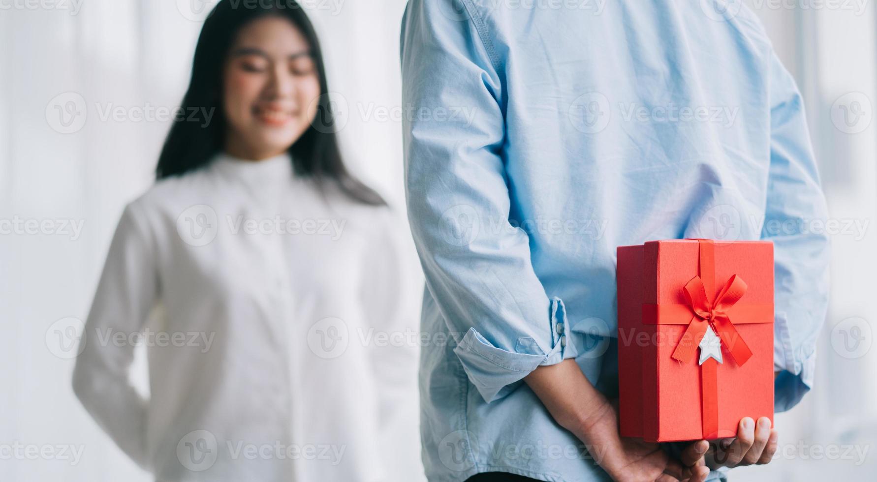 asiatisk tjej känner sig glad och förvånad över att få gåvor från sin pojkvän på alla hjärtans dag foto