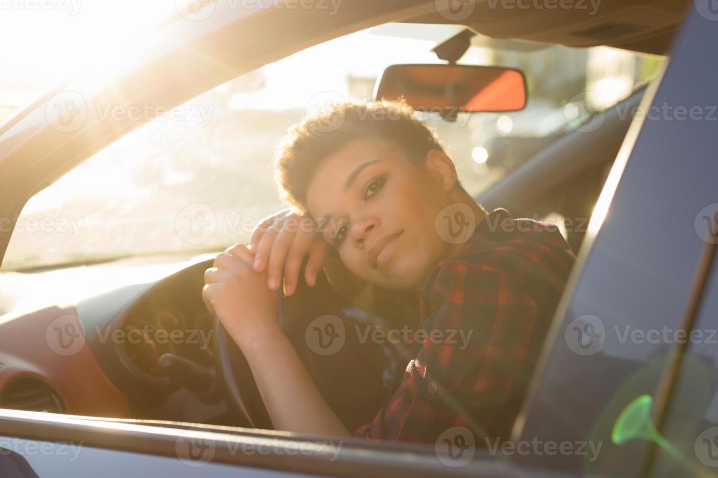seriös och vacker afroamerikansk kvinna med kort hår i en bil, livsstil foto