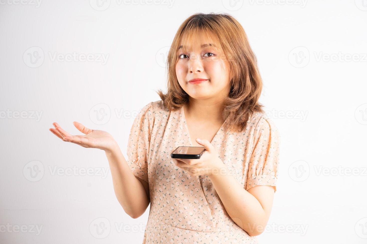 ung asiatisk tjej som håller telefonen med uttryck, gester på bakgrunden foto