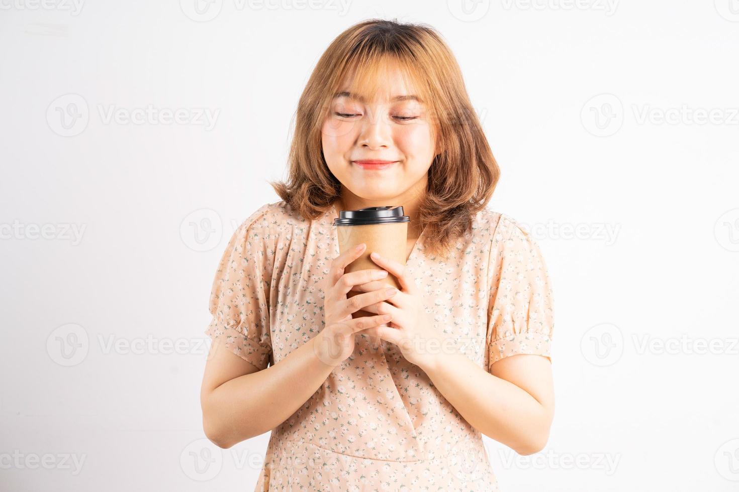 ung asiatisk flicka som håller kaffekoppen med uttryck på bakgrunden foto
