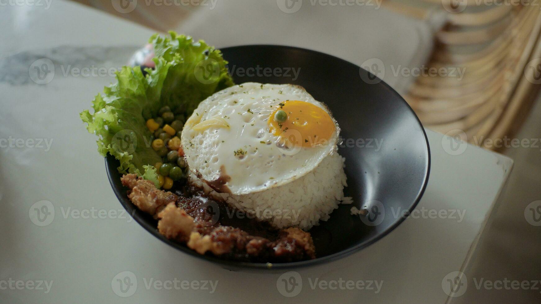 ris skål med solig sida upp ägg, kyckling, grönsaker och sallad på vit tabell i restaurang. foto