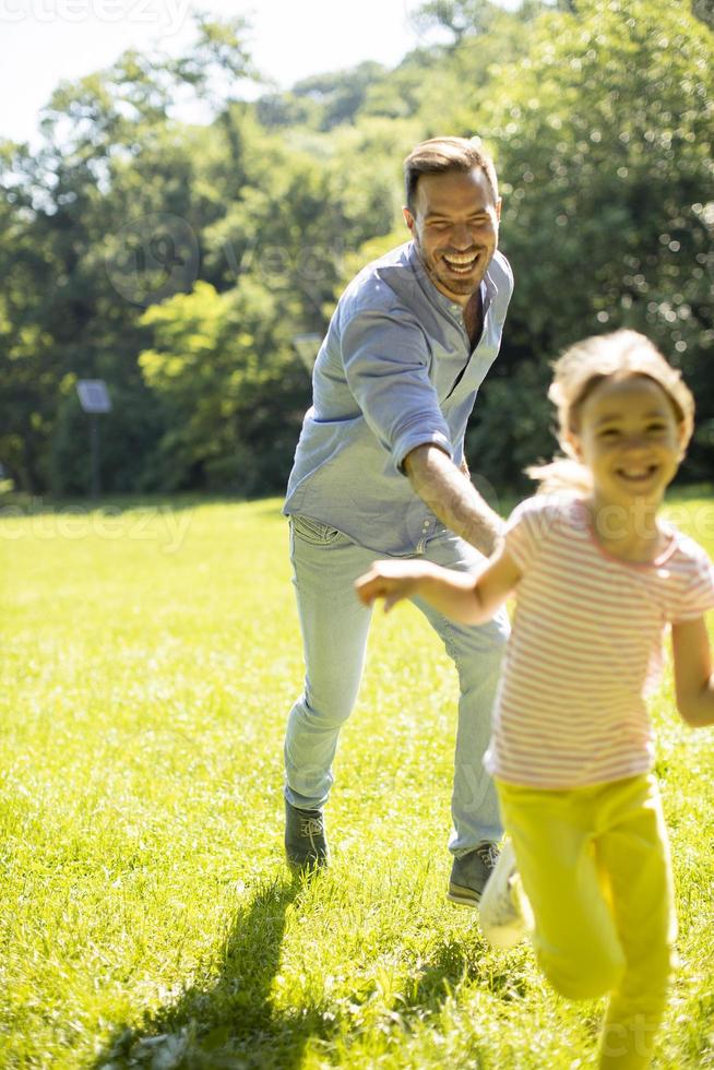 far jagar sin lilla dotter medan han leker i parken foto