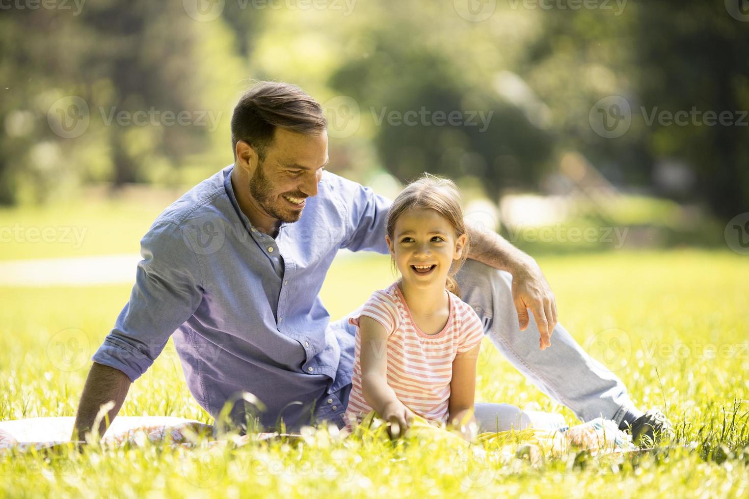 far med dotter som har kul på gräset i parken foto