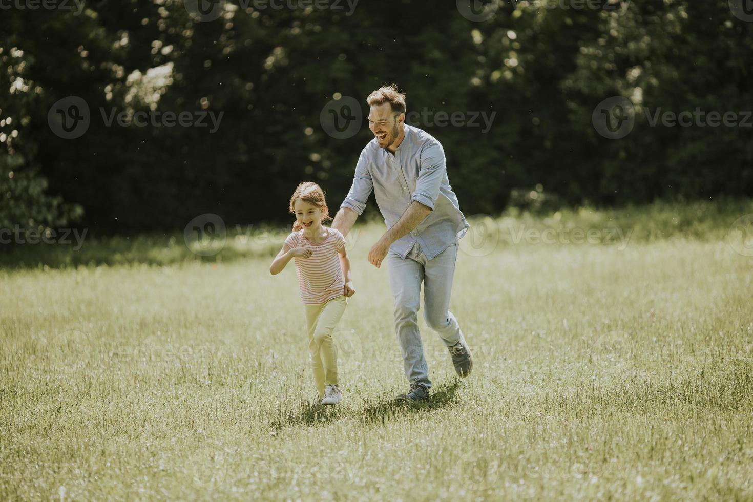 far jagar sin lilla dotter medan han leker i parken foto