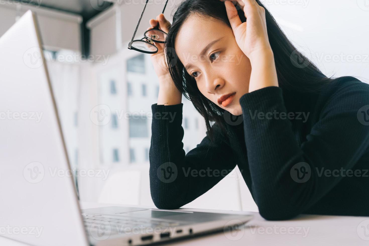 stressad asiatisk kvinna som arbetar hemifrån foto