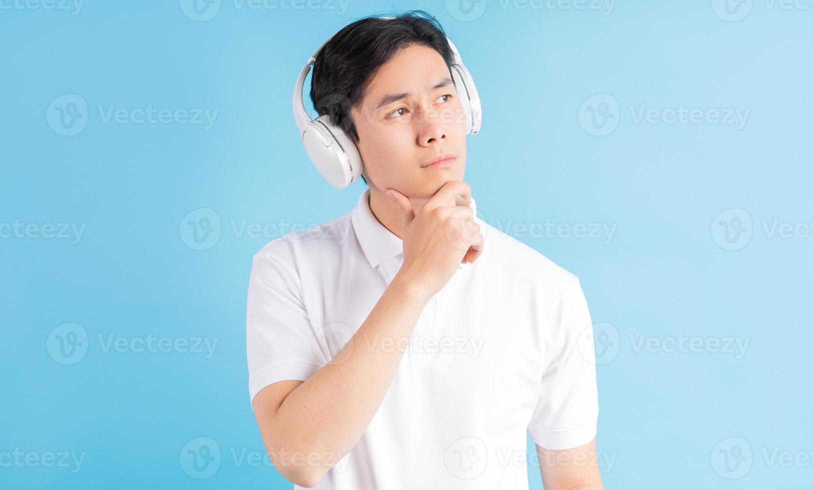 asiatisk man lyssnar på musik och tänker foto