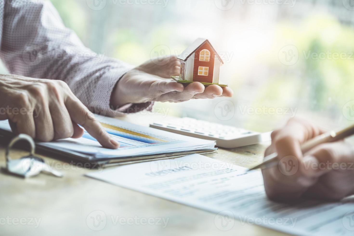 fastighetsmäklare som diskuterar om lån och räntor för att köpa hus till kunder som kommer i kontakt. kontrakt och avtalskoncept. foto