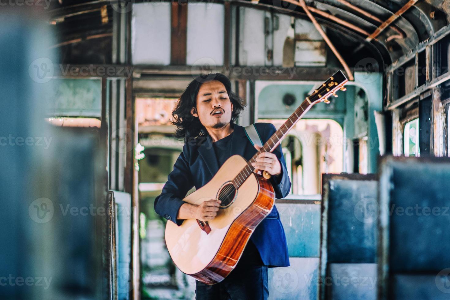 man spelar gitarrrock så upphetsad musikunderhållning, man spelar gitarr på tåget foto