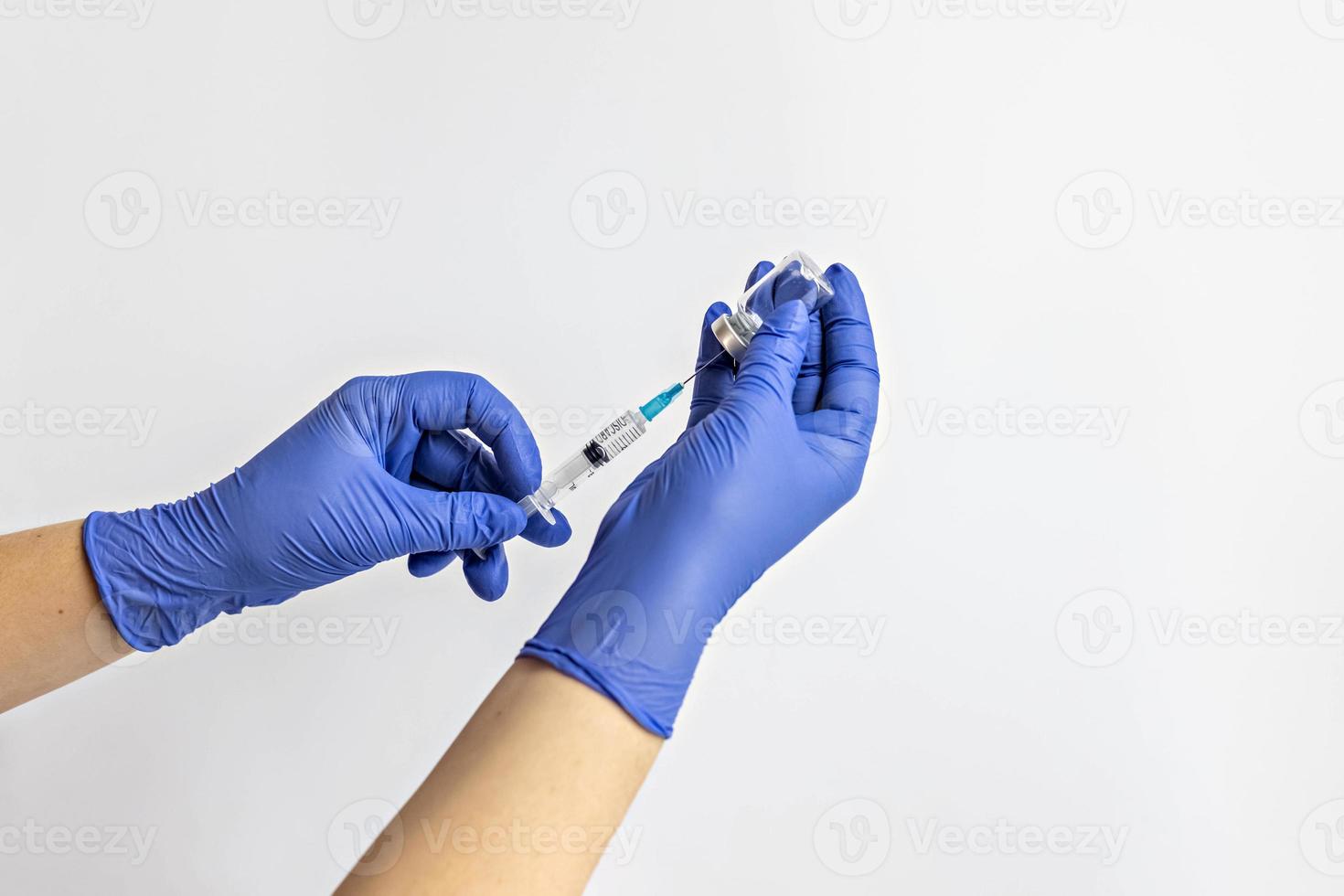en medicinsk arbetare i medicinska handskar drar en dos av coronavirusvaccin i en spruta. begreppet vaccination, immunisering, förebyggande av människor från covid-19 foto