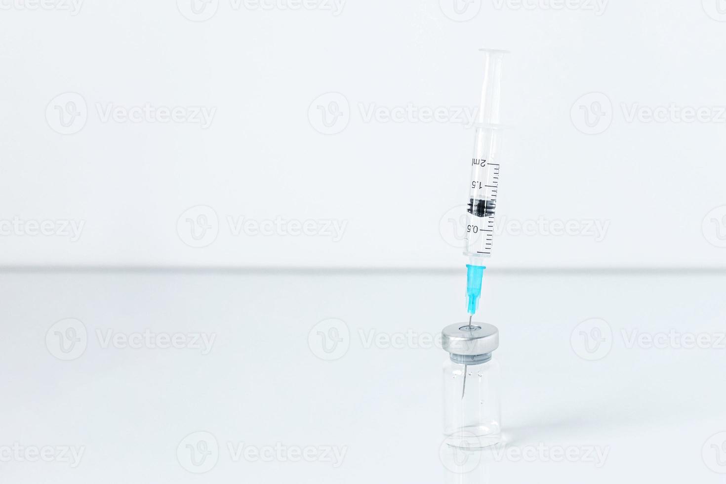 sprutnål i injektionsflaska, coronavirusvaccin, injektionsflaskados. förebyggande, medicinskt koncept, covid-19-immunisering. foto