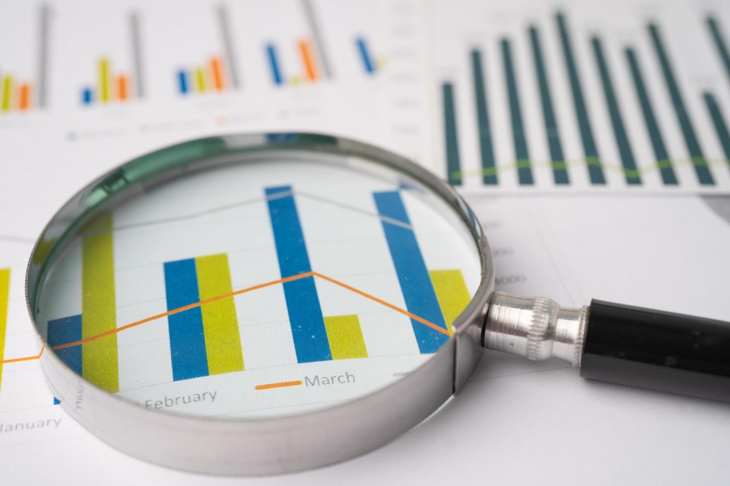 förstoringsglas på diagram diagrampapper. finansiell utveckling, bankkonto, statistik, investeringsanalys, forskningsdataekonomi, börshandel, affärskontorsföretagskoncept. foto