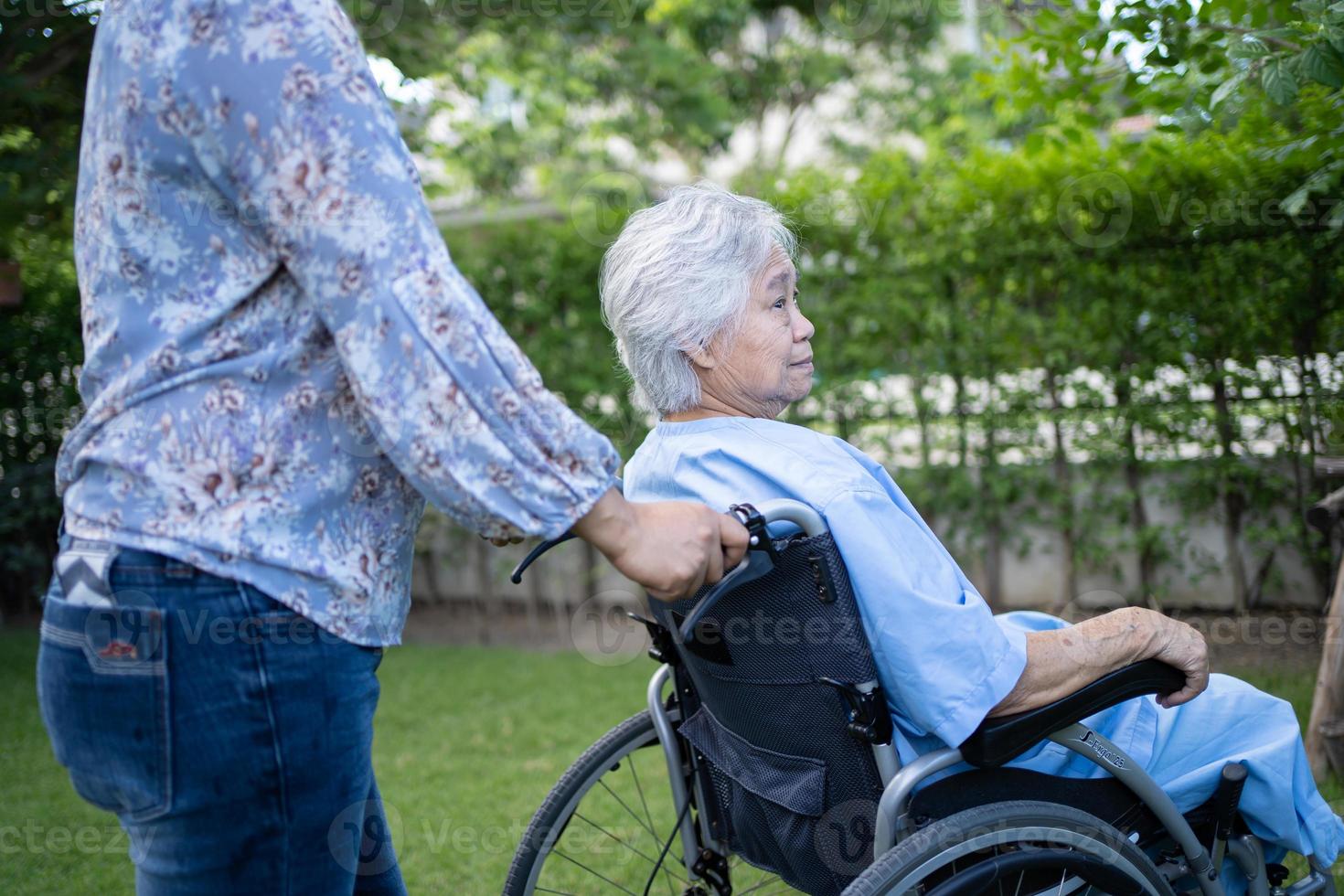 läkarehjälp och vård asiatisk senior eller äldre gammal damkvinnapatient som sitter på rullstol på parkerar på vårdavdelningen, hälsosamt starkt medicinskt koncept. foto