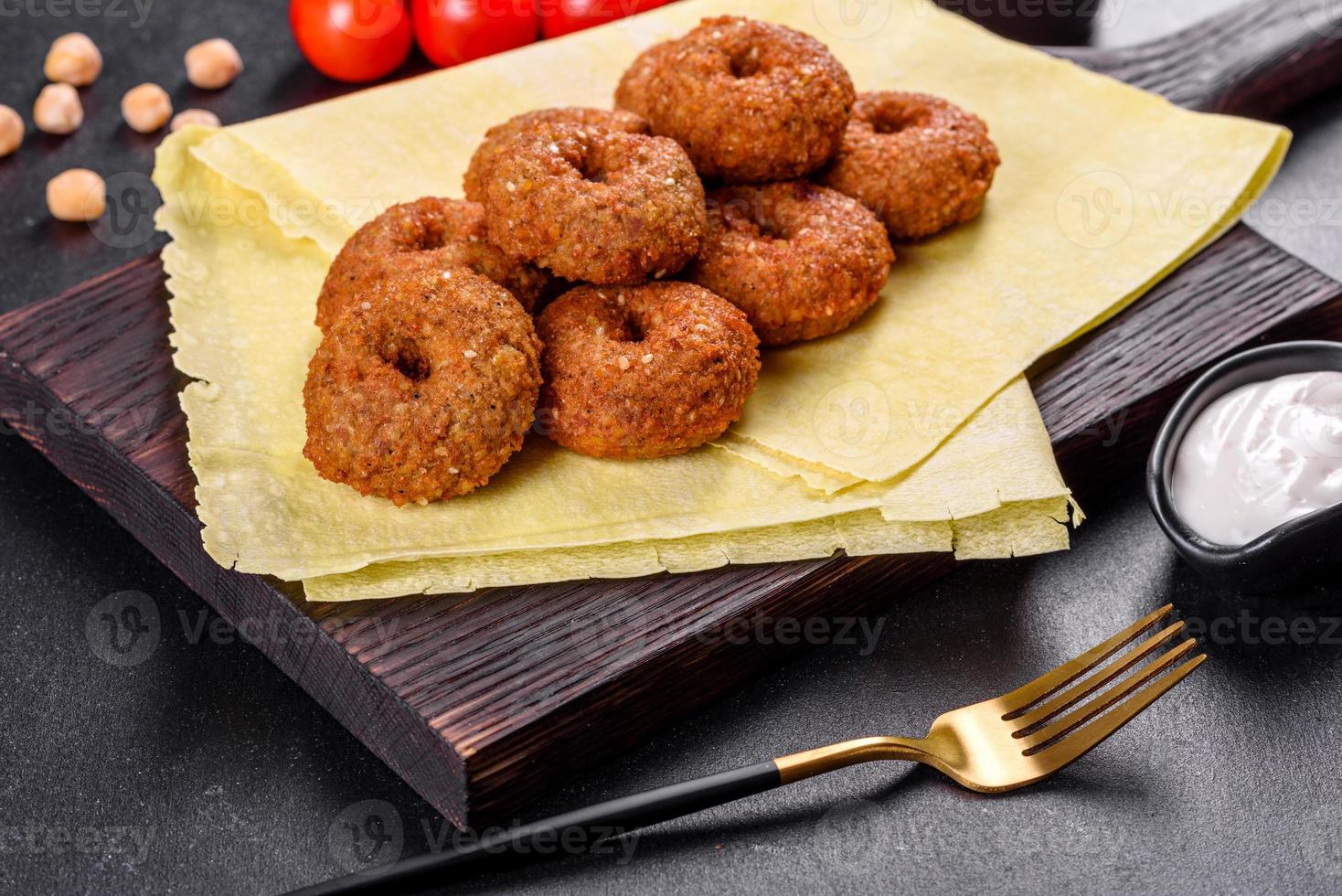 vacker läcker färsk kikärta falafel med såser på en konkret bakgrund foto