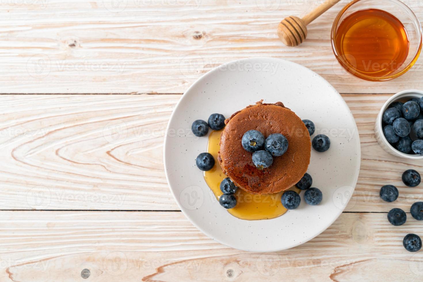 chokladpannkakabunt med blåbär och honung på en tallrik foto