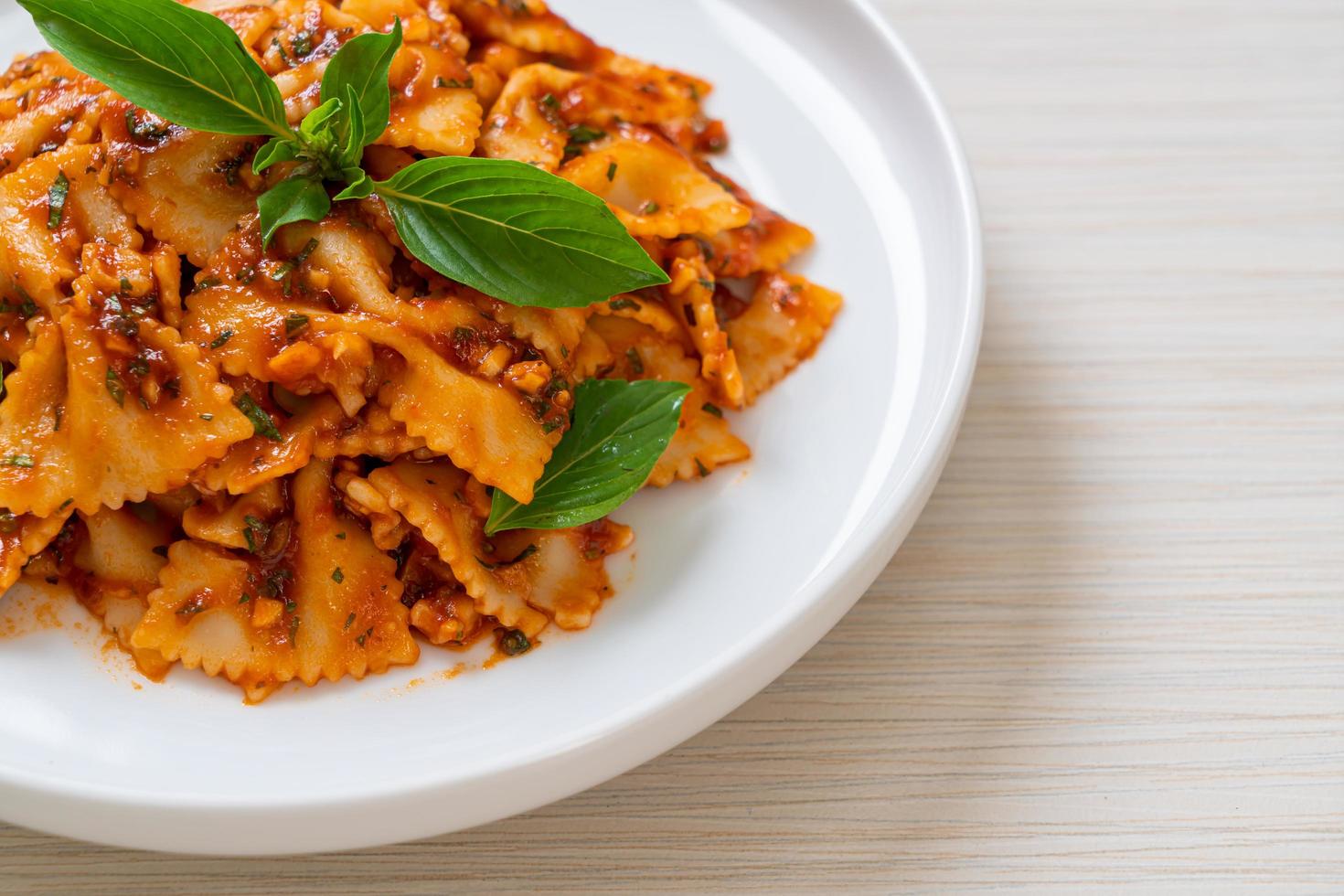 farfalle pasta med basilika och vitlök i tomatsås - italiensk sås foto