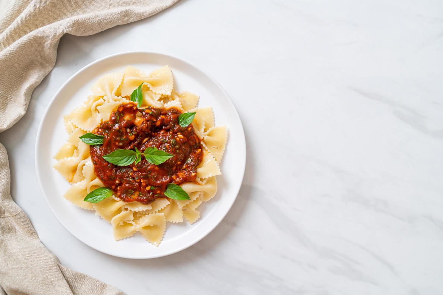 farfalle pasta med basilika och vitlök i tomatsås - italiensk sås foto