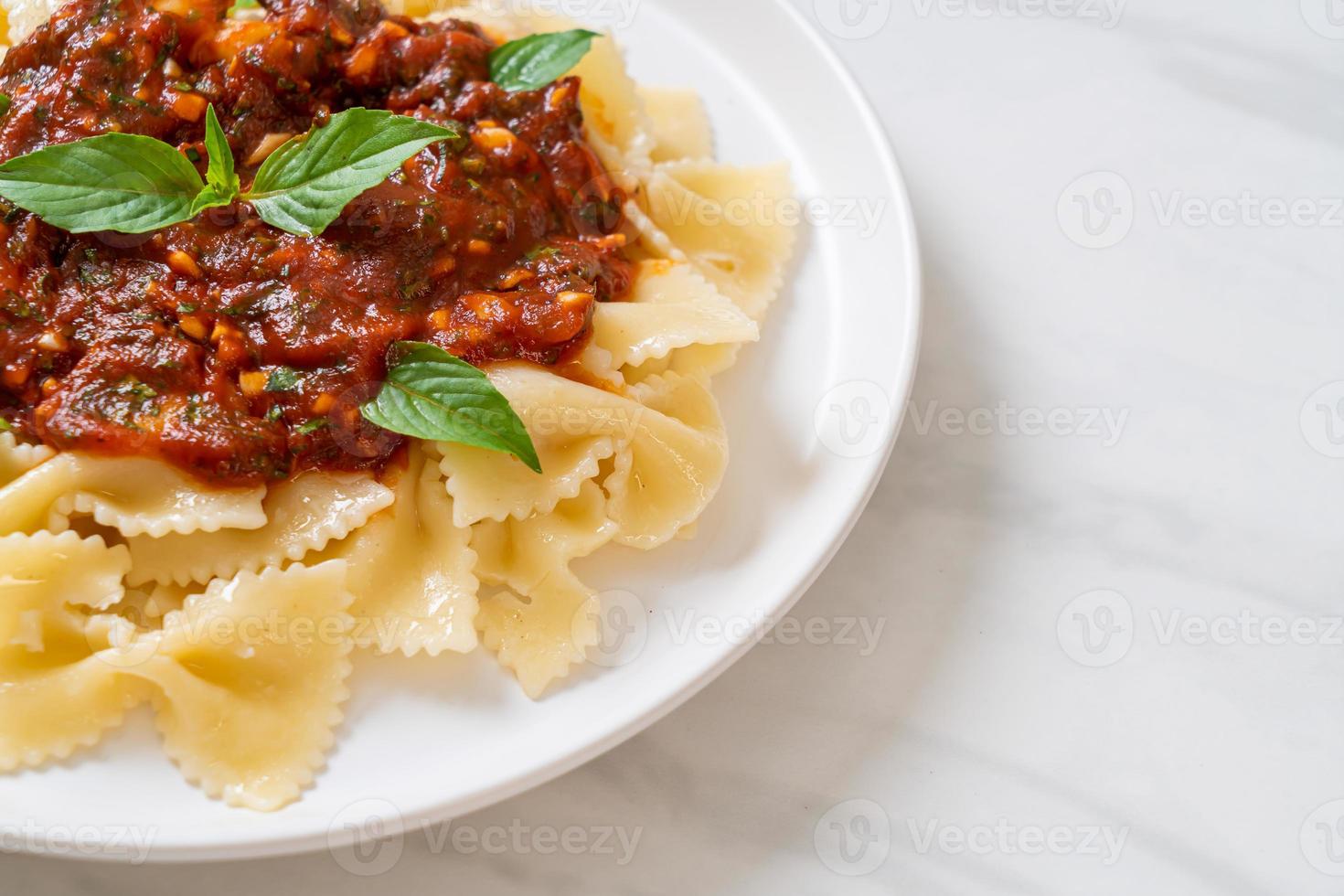 farfalle pasta med basilika och vitlök i tomatsås - italiensk sås foto