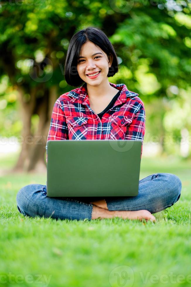 asiatiska kvinnor ler glatt och bärbar dator. arbeta online online kommunikation meddelanden online lärande online kommunikation koncept foto