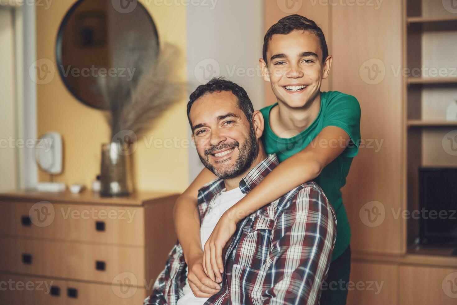 porträtt av Lycklig far och son på Hem. de är omfamnande. foto