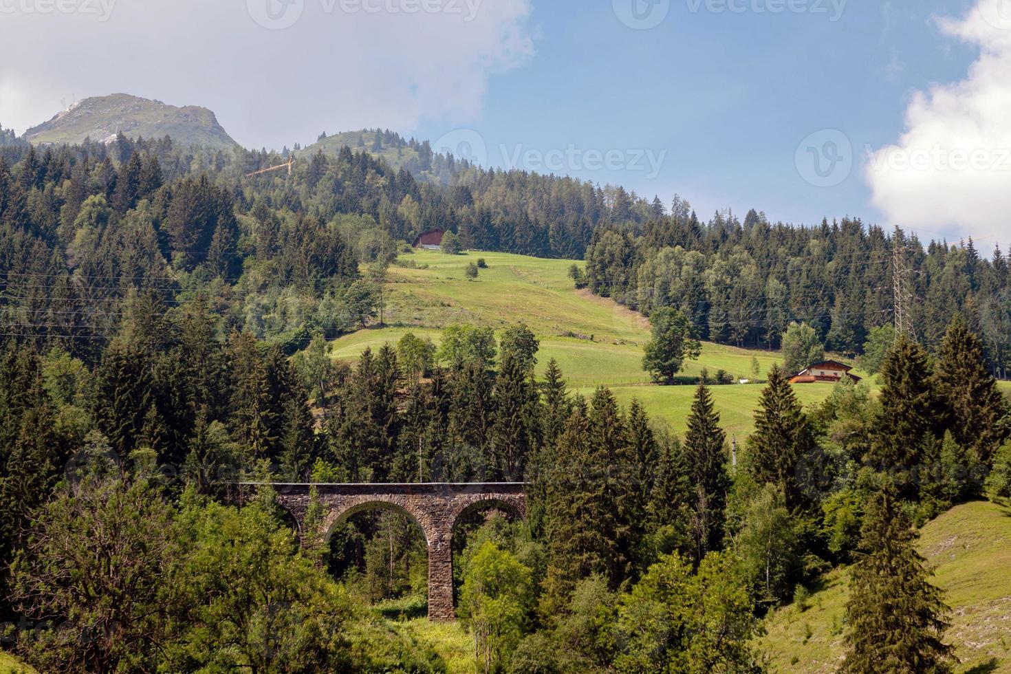 ett pittoreskt alpint landskap med en gammal järnvägsbro. Österrike. foto