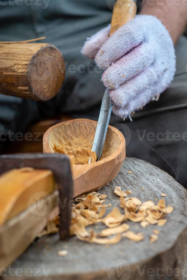 hantverkare demonstrerar processen att göra träskedar foto