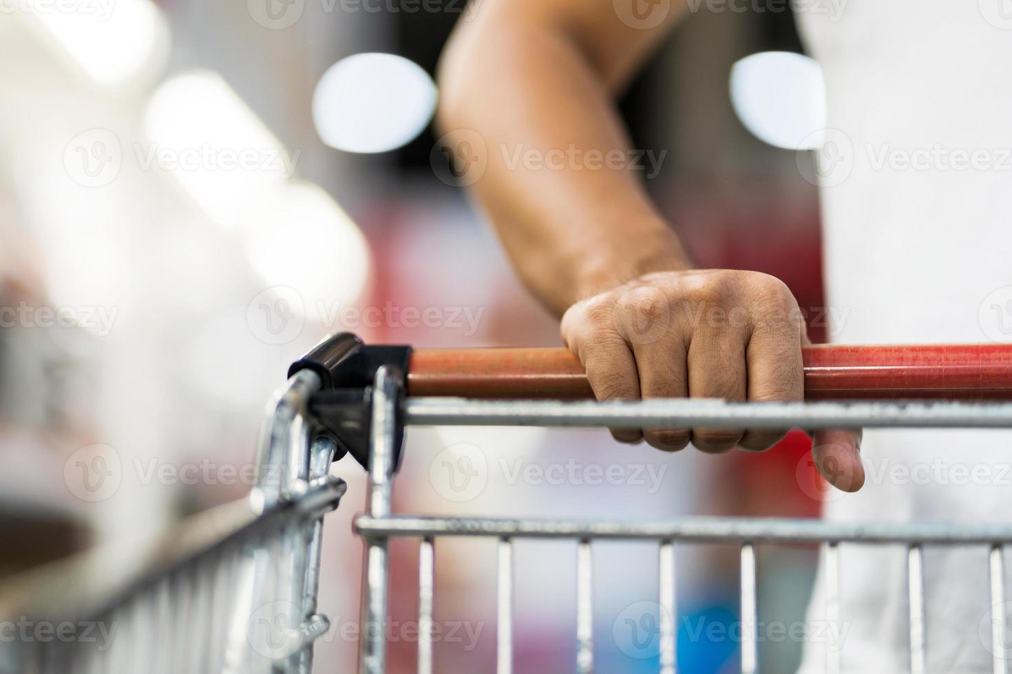 närbild av den man som skjuter shoppingvagnen i en stormarknad foto
