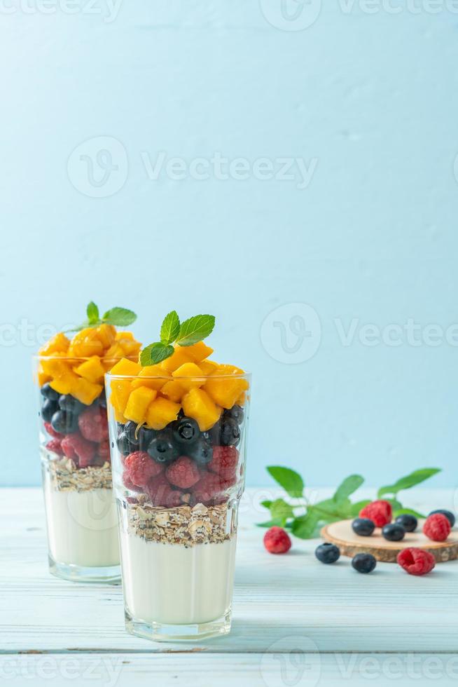 hemlagad mango, hallon och blåbär med yoghurt och granola - hälsosam matstil foto