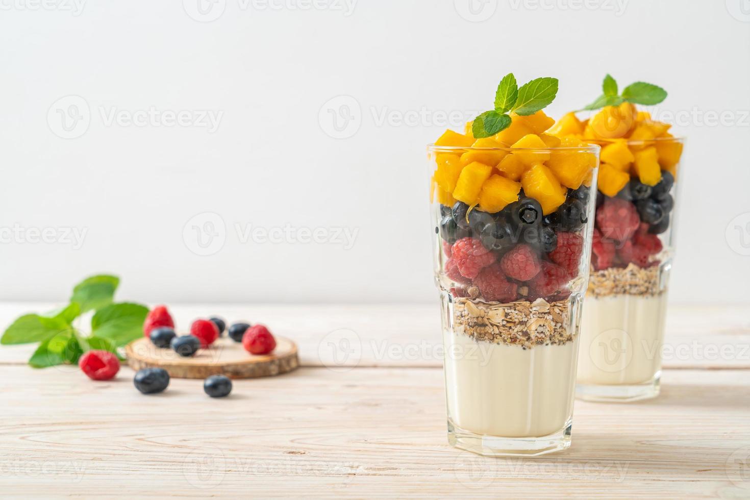 hemlagad mango, hallon och blåbär med yoghurt och granola - hälsosam matstil foto