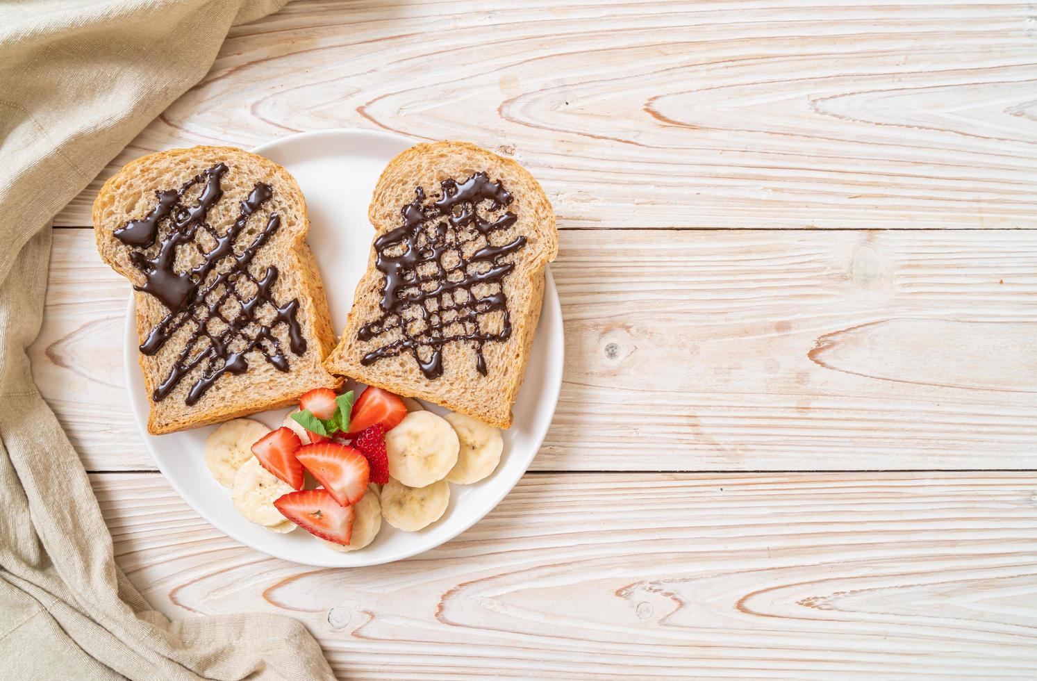 helvete bröd rostat med färsk banan, jordgubbe och choklad till frukost foto