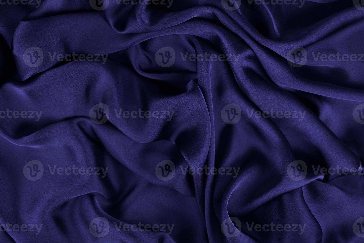 abstrakt satin silkesduk, tyg textil drapering med veck vågiga veck. med mjuka vågor, vinkar i vinden. textur av skrynkligt papper foto
