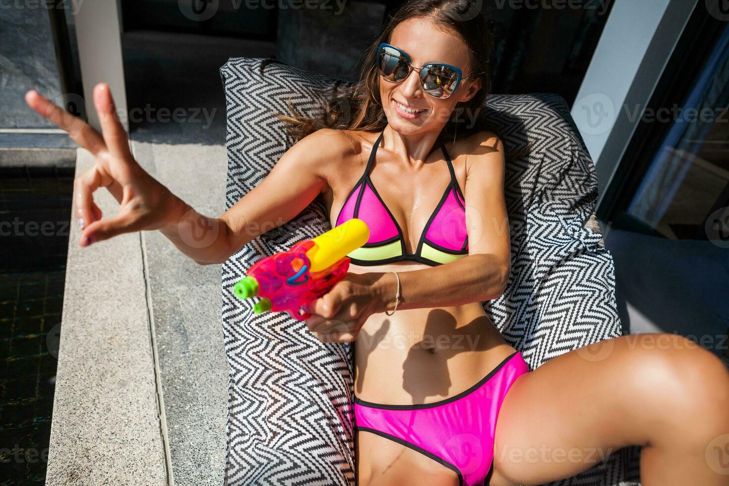 sexig kvinna i färgrik bikini spelar har roligt på sommar sommar slå samman på semester i thailand foto