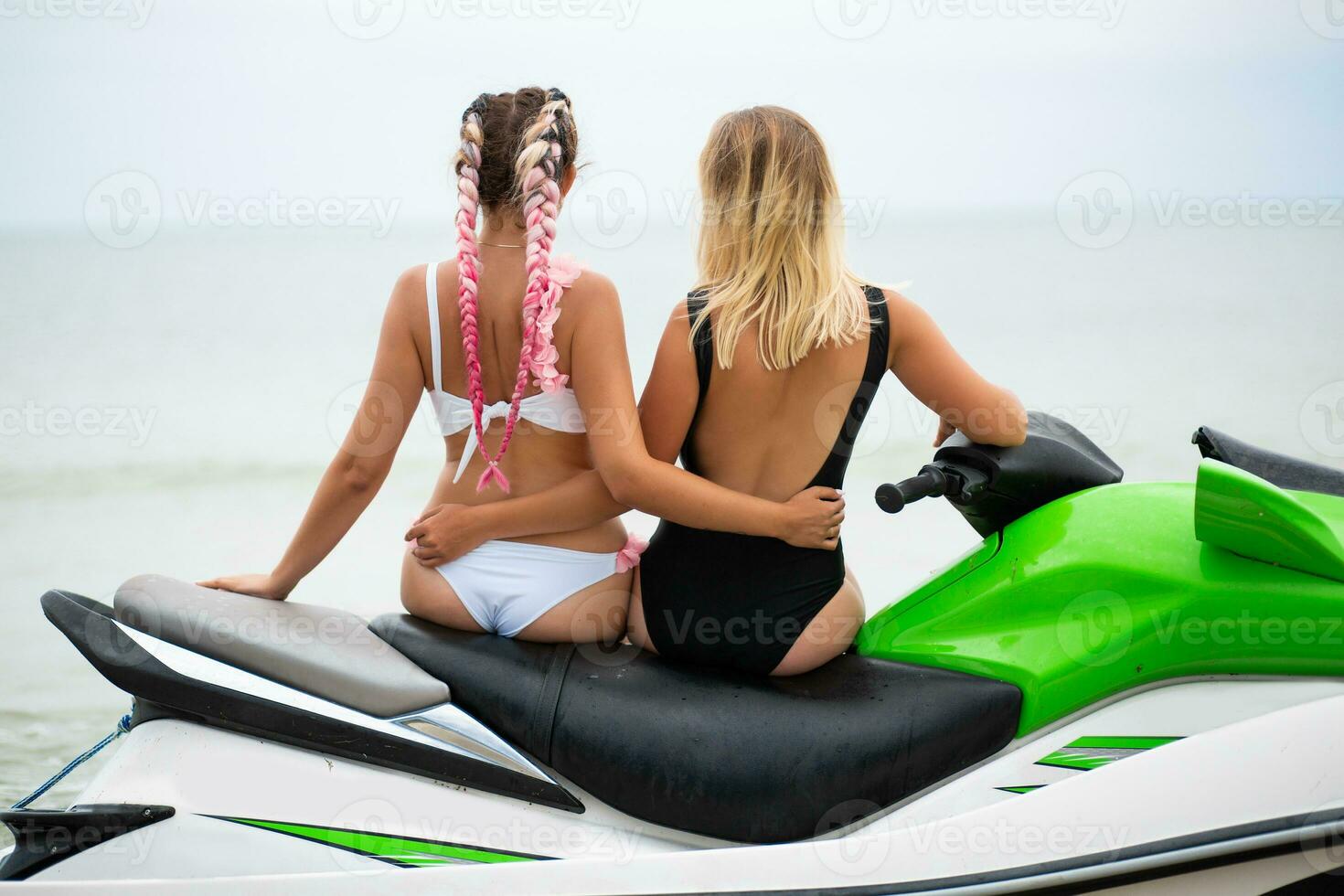 två sexig kvinnor i bikini på vatten skoter i hav sommar stil foto